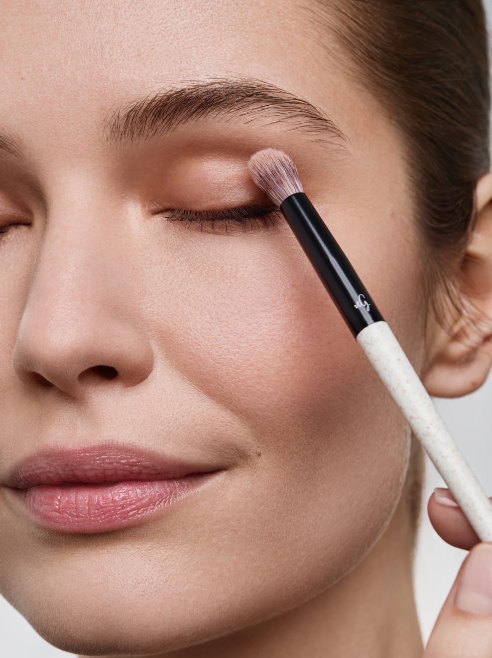 Model wendet Brush 05 auf dem Augenlied an