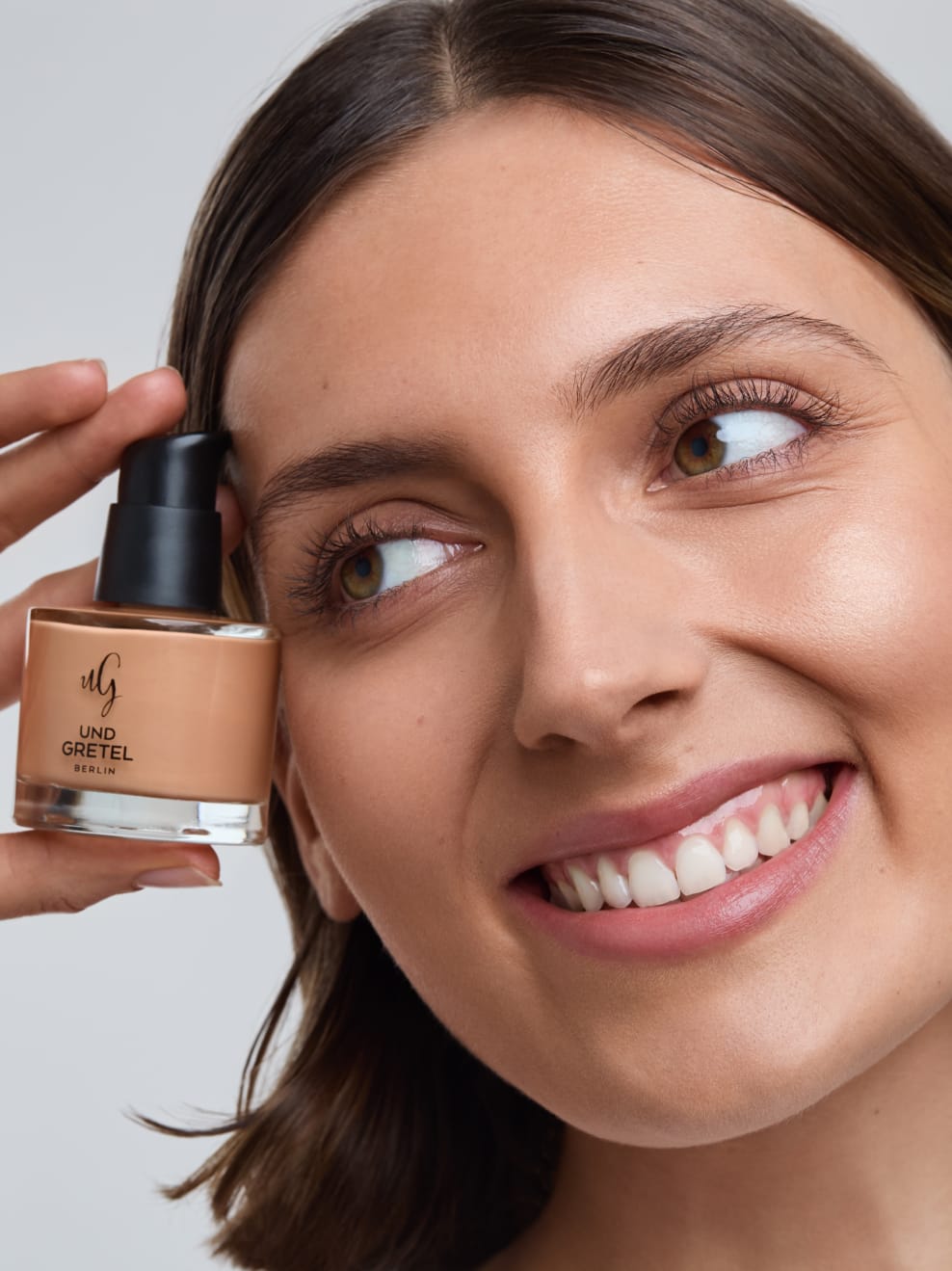 lächelndes Modelgesicht mit BESTE 02 in der Hand