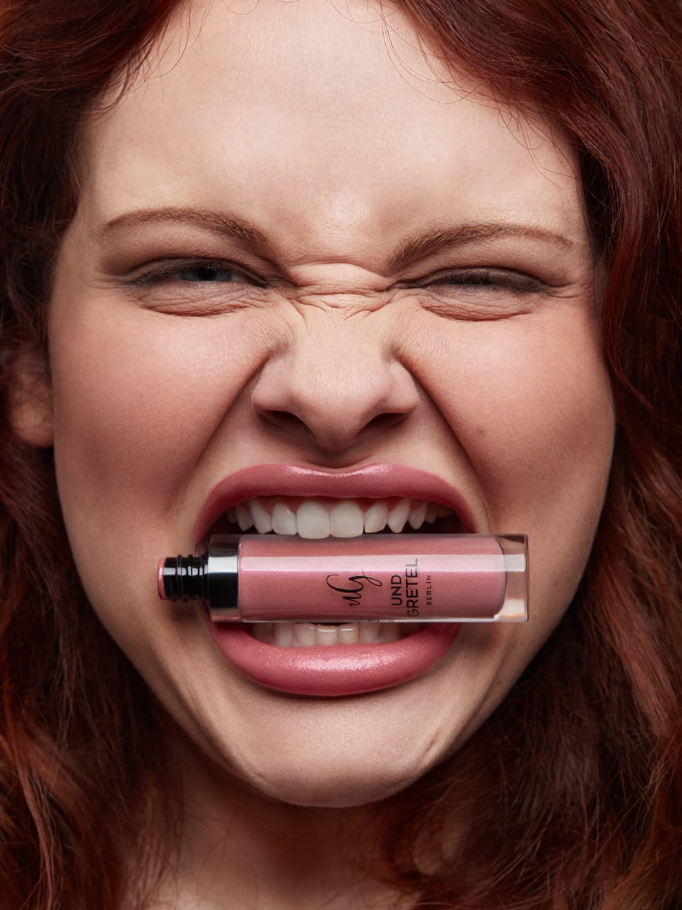 Kampagnenbild Model trägt Knutzen 03 und hält Lipgloss zwischen den Zähnen