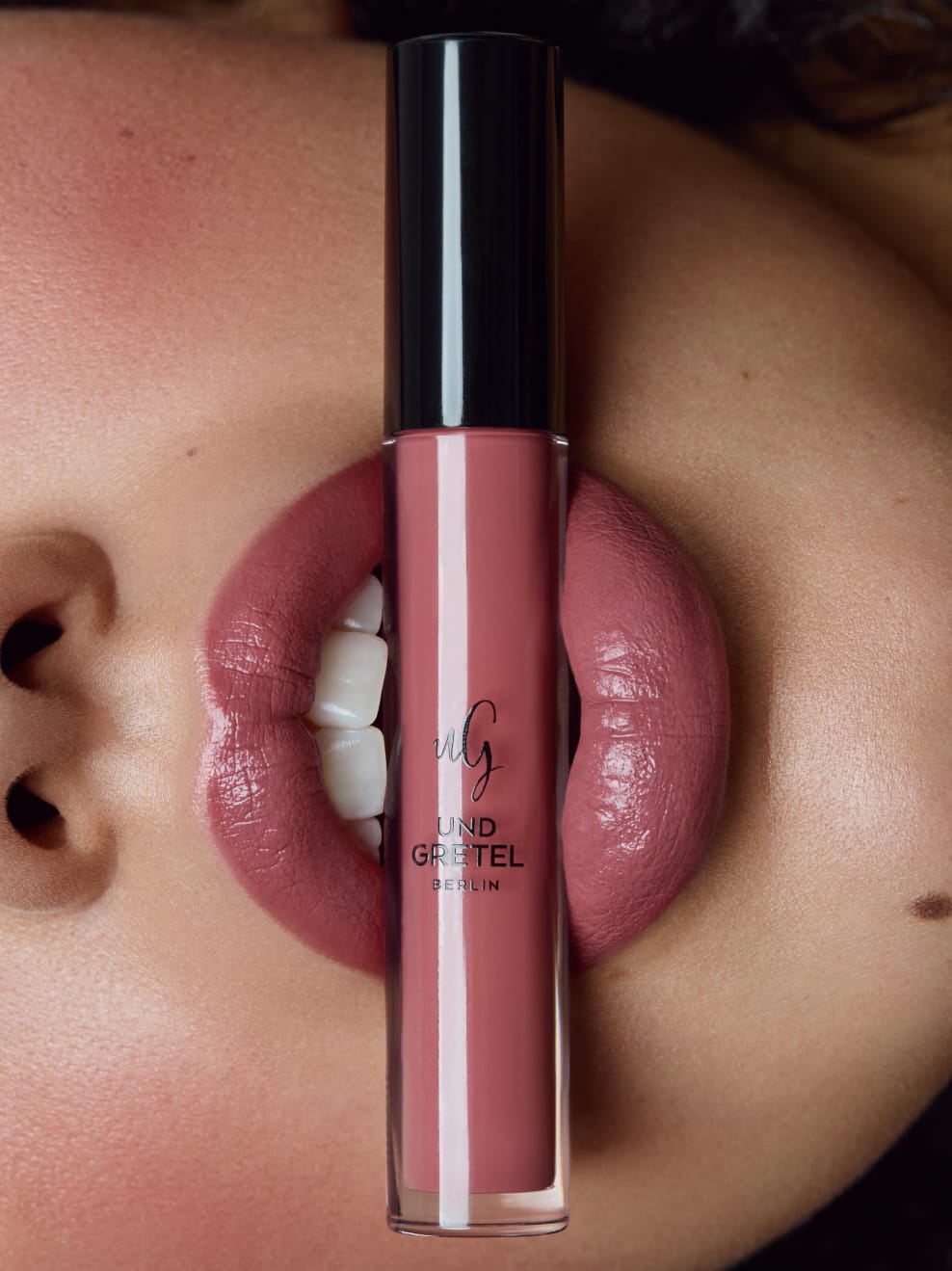 Nahaufnahme Model hält Kus 03 zwischen den Lippen und ist geschminkt mit Kus 03
