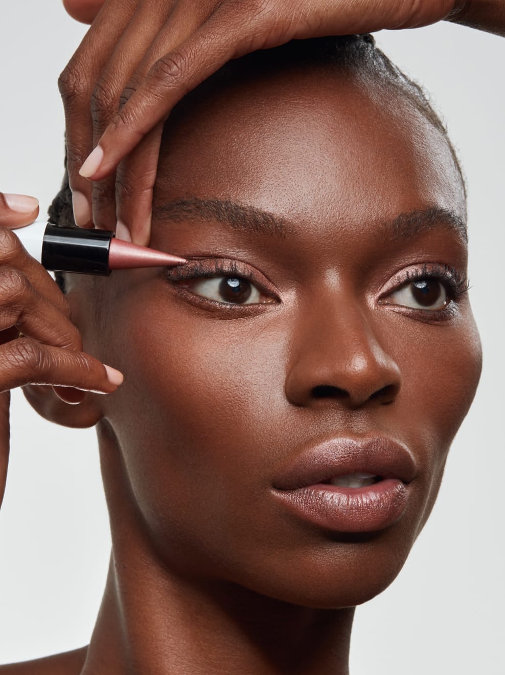 Model hält Luk 05 am Auge und schminkt sich