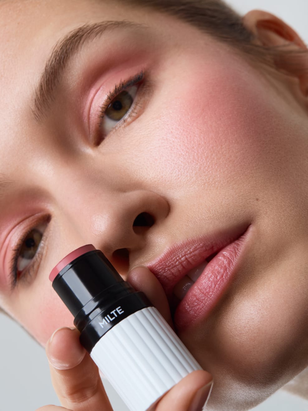 Model geschminkt mit Milte Blush 01 und hält den Stick in der Hand