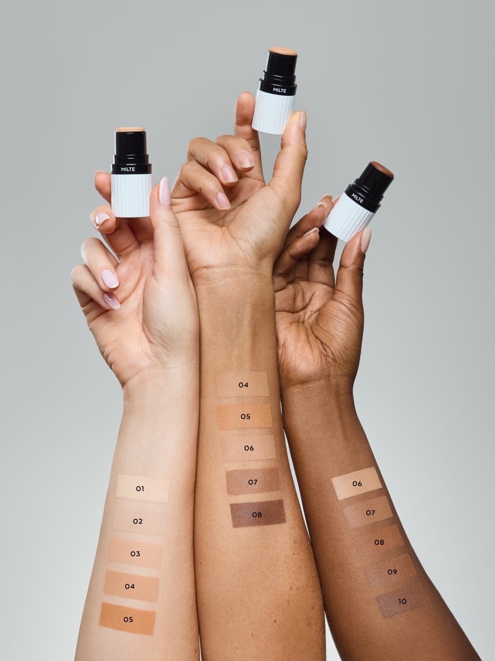 3 Arme mit jeweils Milte Foundation in den Händen und auf den Unterarmen Swatch Vergleiche aller Farben