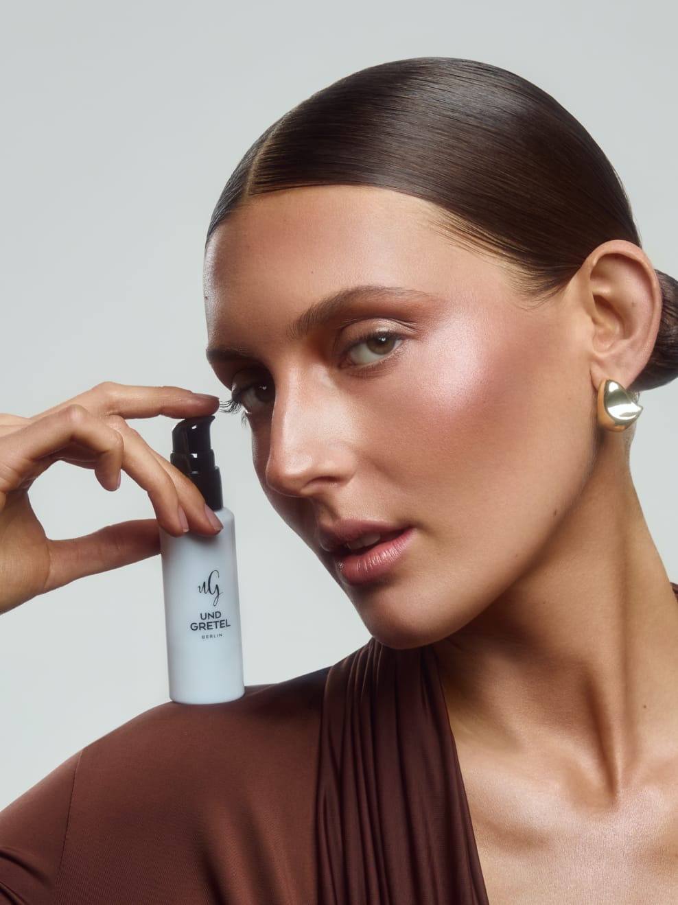 Model mit Vlitter aufgetragen und Flasche in der Hand