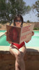 Frau mit rotem Badeanzug und Sommer Sale Zeitung am Pool